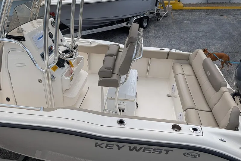Slide: The Image of 2021 Key West 219 FS boat interior with seating and console, parked outdoors. - 7