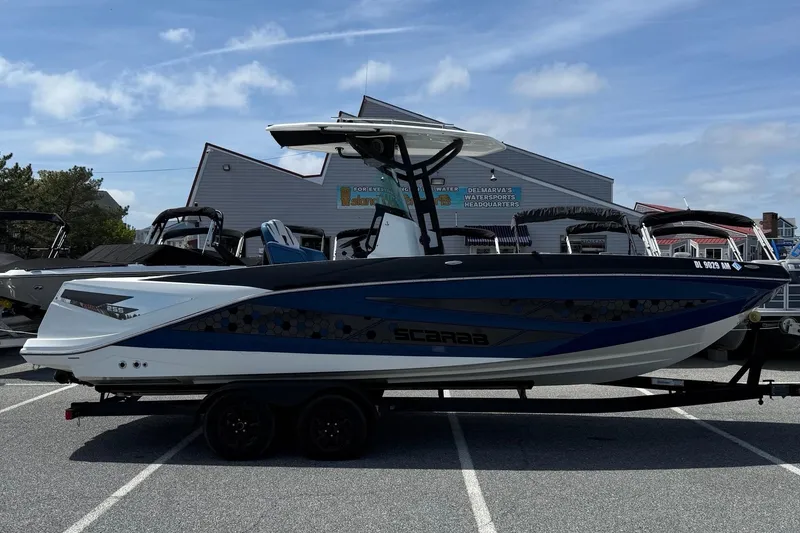 The Image of 2021 Scarab 255 Open ID boat on trailer, parked outdoors under blue sky. - 1