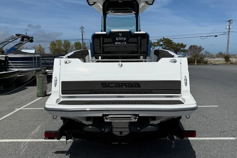 Slide: The Image of 2021 Scarab 255 Open ID boat, rear view in parking lot, clear sky background. - 7