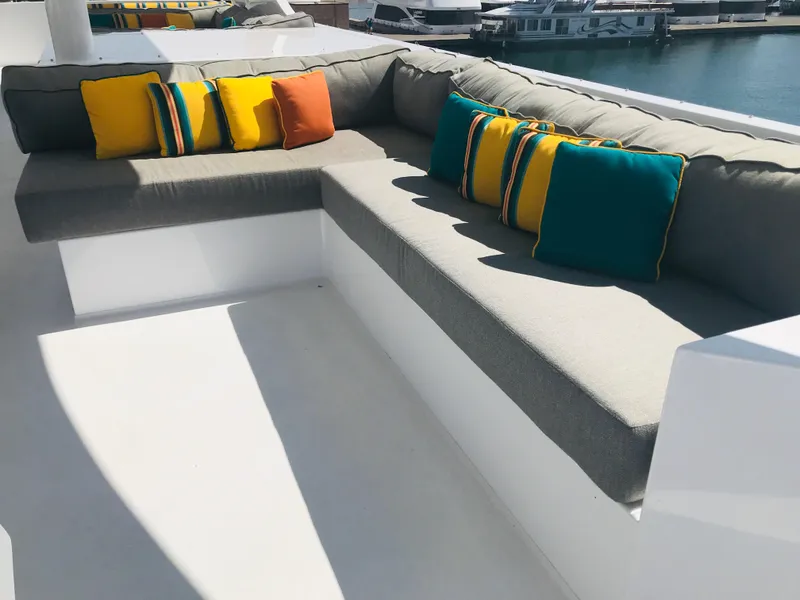 Slide: The Image of Luxurious Adonia Adonis Trip 3 yacht seating with colorful cushions, docked at marina. - 36