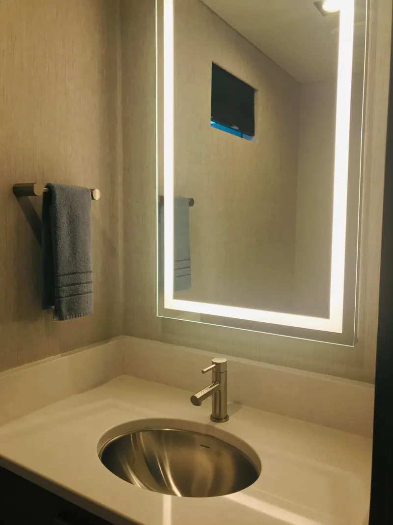 Slide: The Image of Modern bathroom with illuminated mirror, sleek sink, and towel rack in Adonia Adonis Trip 3, 2018. - 5