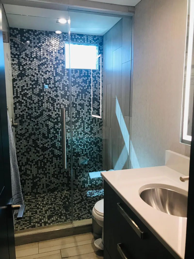 Slide: The Image of Modern bathroom with mosaic-tiled shower, glass door, and sleek vanity in Adonia Adonis Trip 3 RV. - 8
