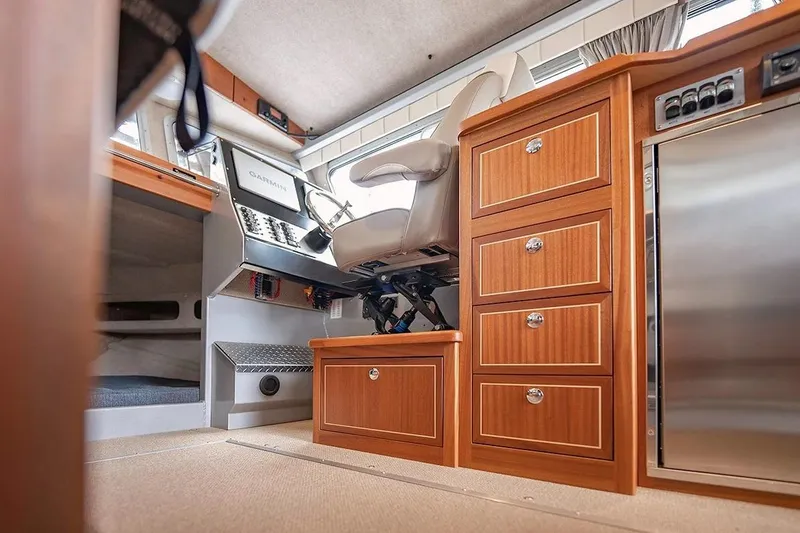 Slide: The Image of Interior of 2026 KingFisher 3225 GFX Offshore boat with helm, wooden cabinetry, and modern controls. - 19