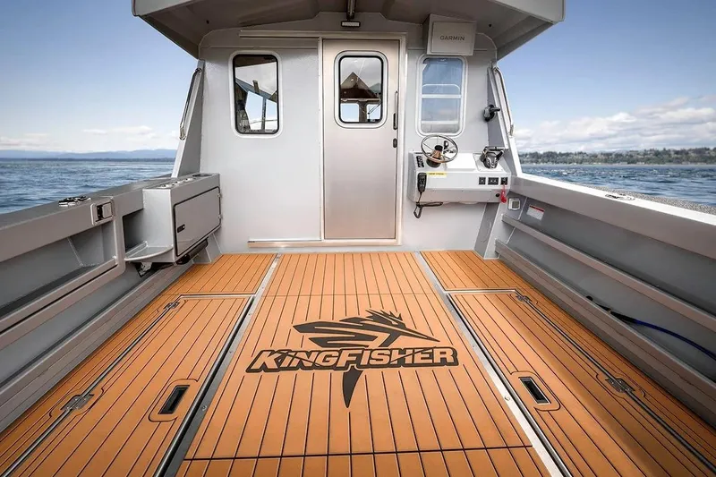 Slide: The Image of 2026 KingFisher 3225 GFX Offshore boat interior with wood flooring and steering console. - 3