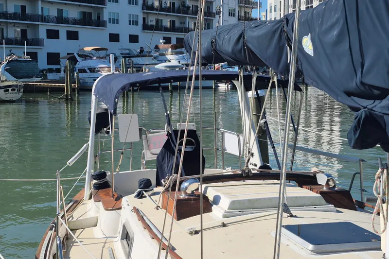 Slide: The Image of 1987 Morgan 384 sailboat docked in a marina, surrounded by modern buildings. - 12