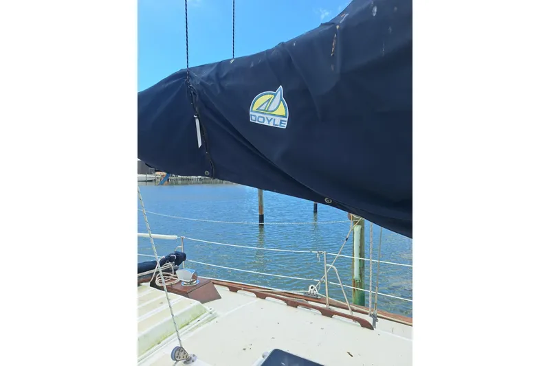 Slide: The Image of 1987 Morgan 384 sailboat with Doyle sail cover, docked by calm waters. - 15