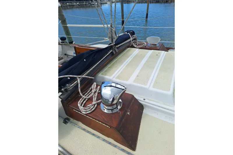 Slide: The Image of 1987 Morgan 384 sailboat deck with ropes and winch by the water. - 16