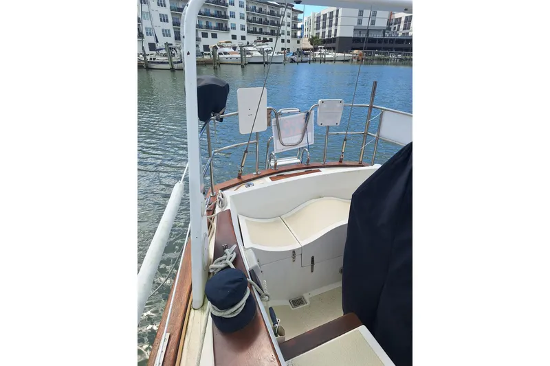 Slide: The Image of 1987 Morgan 384 sailboat cockpit with marina view, featuring seating and nautical equipment. - 19