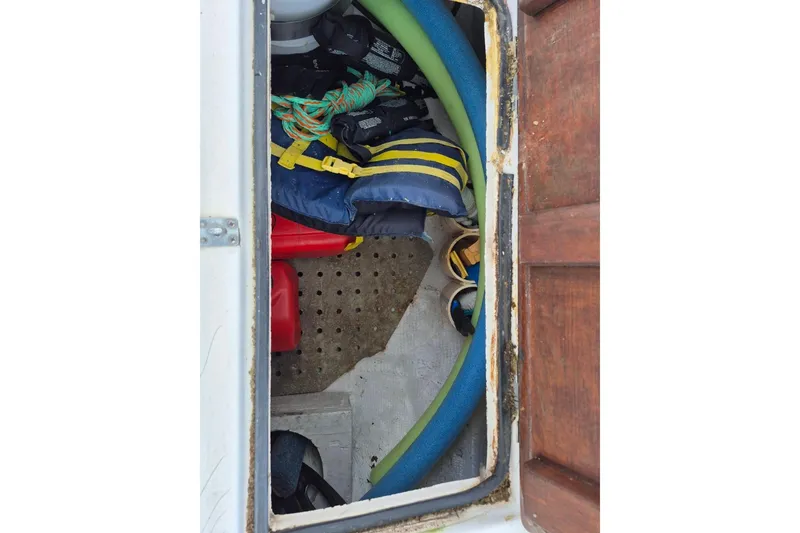 Slide: The Image of Storage compartment on a 1987 Morgan 384 sailboat with life jackets and pool noodles. - 23