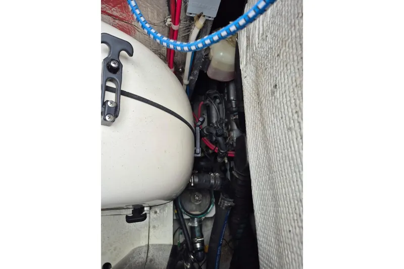 Slide: The Image of Engine compartment of a 1987 Morgan 384 sailboat, showing various mechanical components and wiring. - 36
