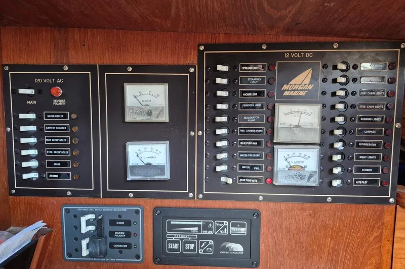 Slide: The Image of Electrical control panel of a 1987 Morgan 384 sailboat, featuring AC and DC switches. - 38