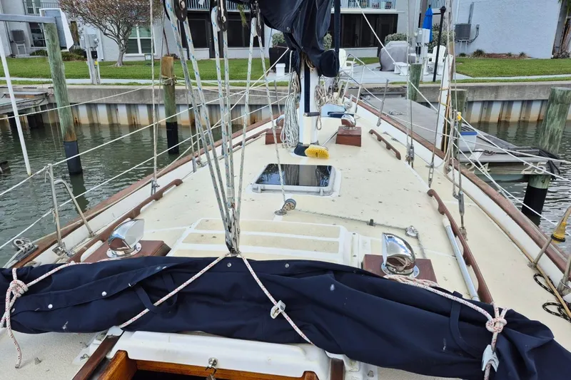 Slide: The Image of 1987 Morgan 384 sailboat deck view at marina, showcasing rigging and dock surroundings. - 4