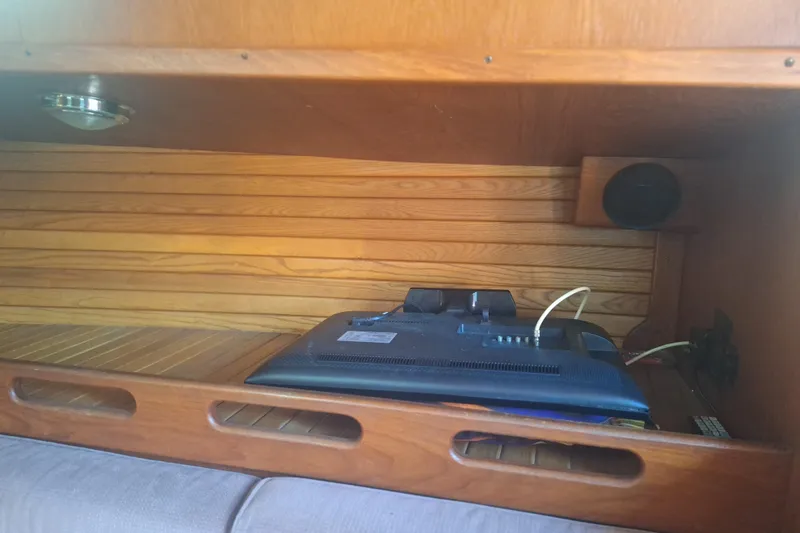 Slide: The Image of Interior of a 1987 Morgan 384 sailboat with wooden cabinetry and electronic equipment. - 44