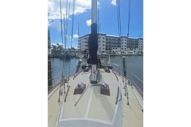 Slide: The Image of 1987 Morgan 384 sailboat docked in marina, clear sky, waterfront buildings in background. - 5