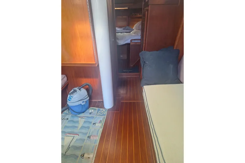 Slide: The Image of Interior of a 1987 Morgan 384 sailboat with wood flooring and a vacuum cleaner. - 50