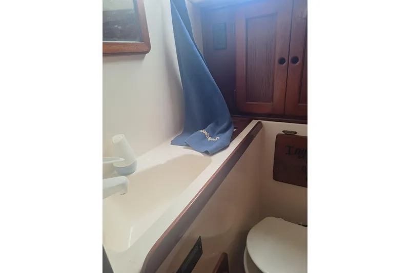 Slide: The Image of 1987 Morgan 384 yacht bathroom with sink, blue towel, and wooden cabinets. - 51