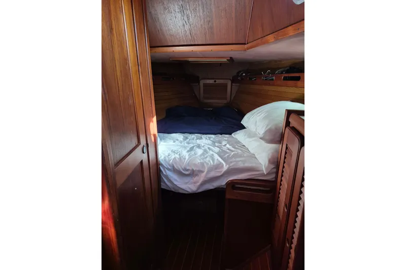 Slide: The Image of Cozy cabin interior of 1987 Morgan 384 sailboat with wooden paneling and comfortable bedding. - 55