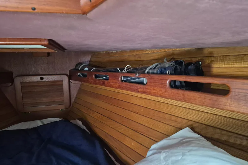 Slide: The Image of Interior of a 1987 Morgan 384 sailboat with wooden paneling and storage space. - 56
