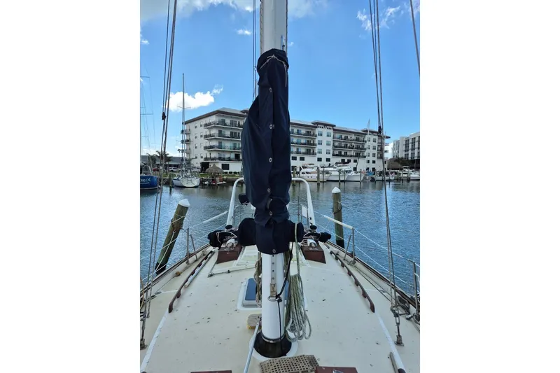 Slide: The Image of 1987 Morgan 384 sailboat docked in marina, with buildings in the background. - 6
