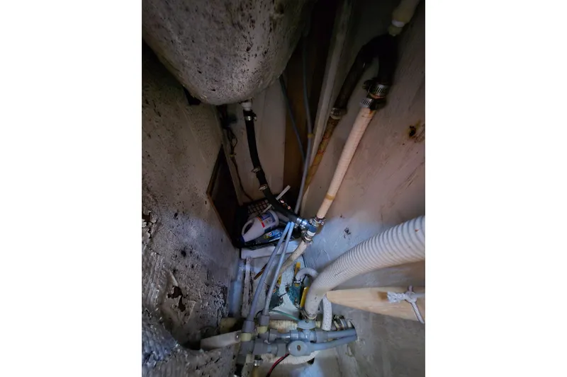 Slide: The Image of Engine compartment of a 1987 Morgan 384 sailboat with visible hoses and pipes. - 60