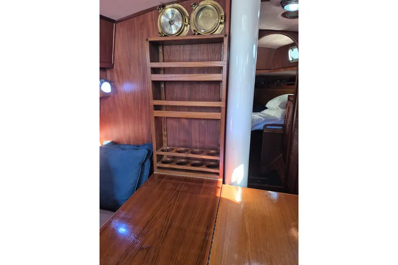 Slide: The Image of Interior of 1987 Morgan 384 sailboat with wooden shelves and nautical decor. - 63