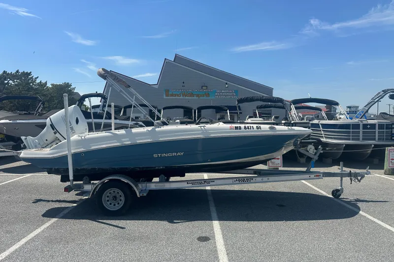 The Image of 2022 Stingray 182 SC boat on trailer in parking lot, sunny day. - 1