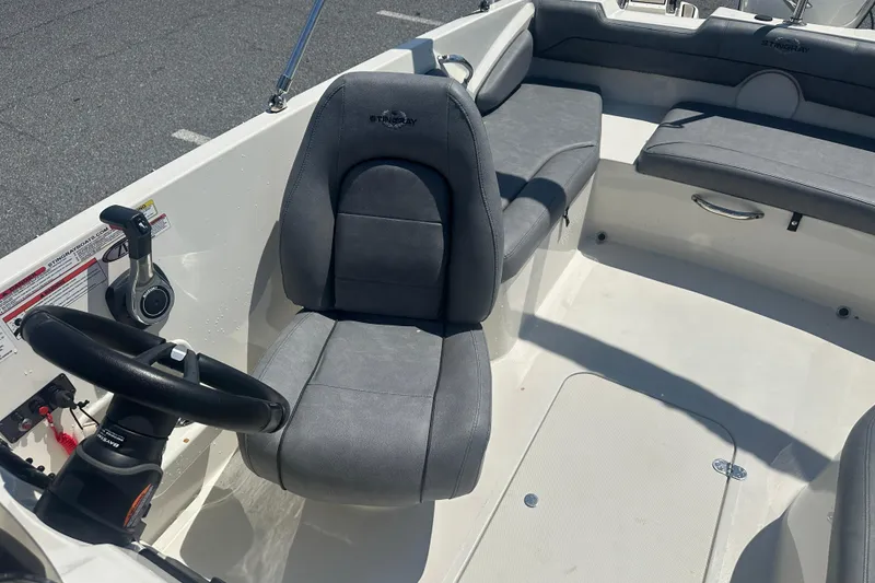 Slide: The Image of 2022 Stingray 182 SC boat interior with gray seating and steering wheel. - 16