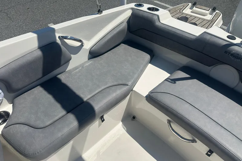Slide: The Image of 2022 Stingray 182 SC boat interior with gray cushioned seating and cup holders. - 17
