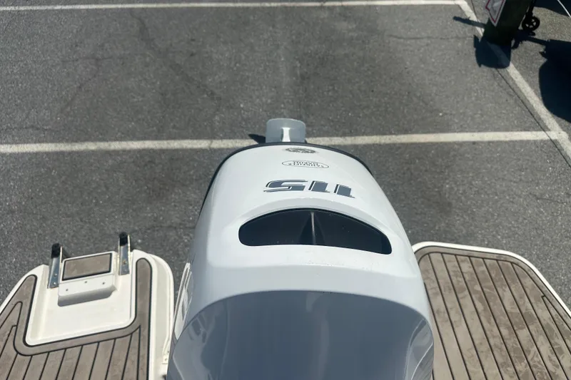 Slide: The Image of 2022 Stingray 182 SC boat engine and deck, parked in a lot. - 20