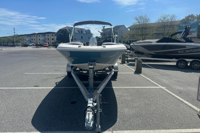 Slide: The Image of 2022 Stingray 182 SC boat on trailer in parking lot under clear sky. - 3