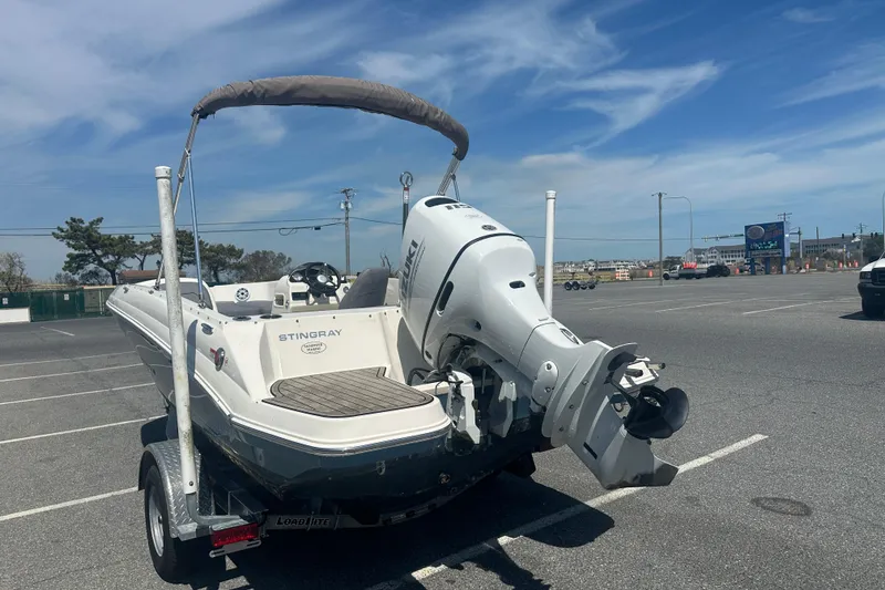 Slide: The Image of 2022 Stingray 182 SC boat on trailer in parking lot under blue sky. - 6