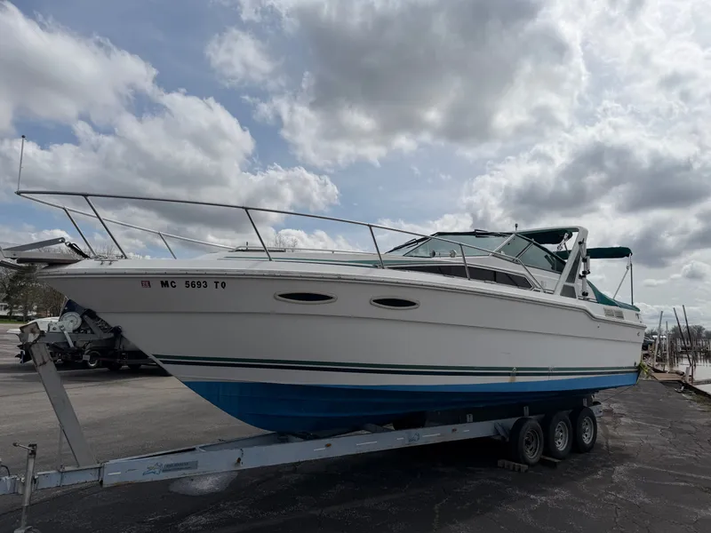 The Image of 1989 Sea Ray 300 Sundancer on trailer under cloudy sky. - 0