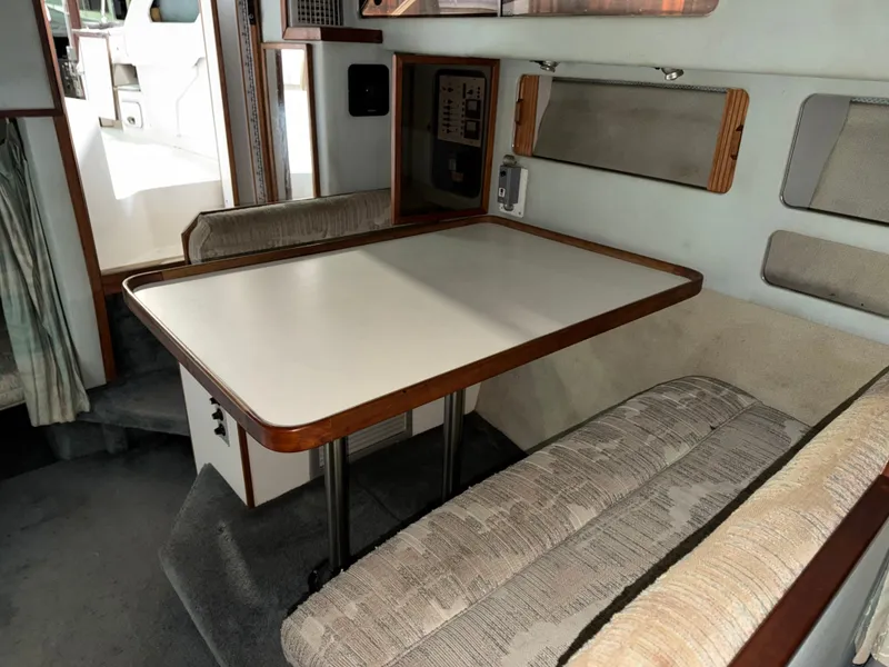 Slide: The Image of Interior of 1989 Sea Ray 300 Sundancer with dining table and seating area. - 16