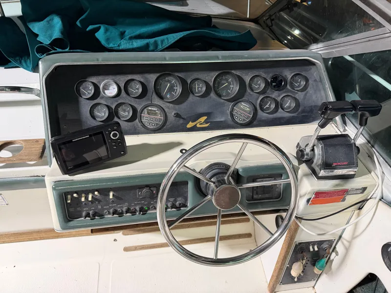 Slide: The Image of Dashboard of a 1989 Sea Ray 300 Sundancer boat with steering wheel and instruments. - 21