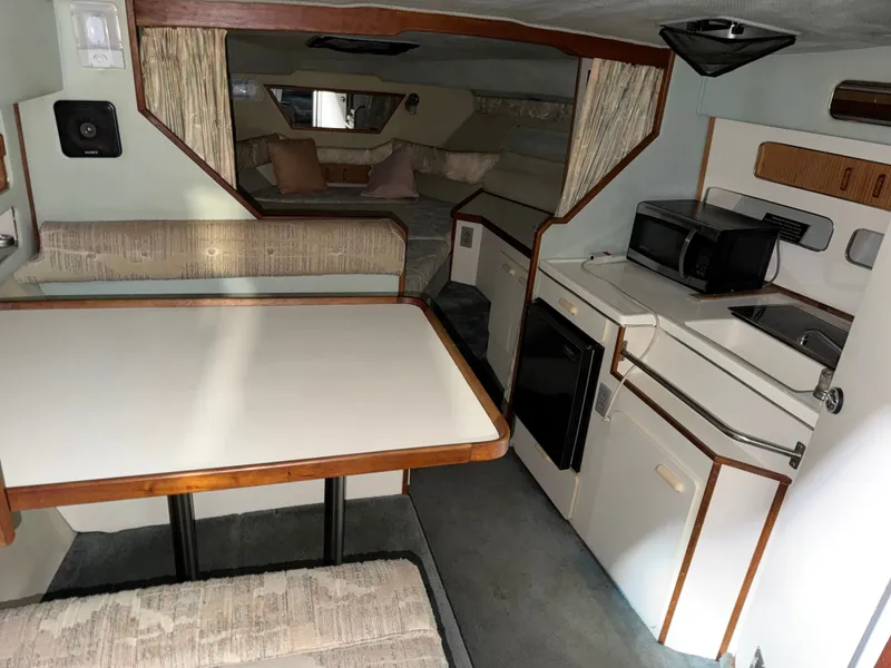 Slide: The Image of Interior of 1989 Sea Ray 300 Sundancer with kitchen and dining area. - 7