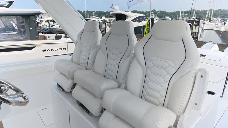 Slide: The Image of Three luxurious, padded seats on a modern boat, surrounded by other boats in the marina. - 21