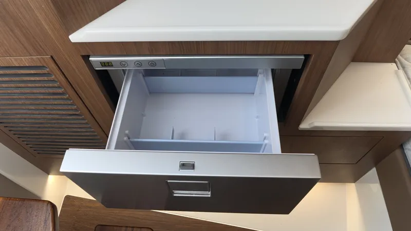 Slide: The Image of Open drawer in a modern boat kitchen with wood paneling. - 30