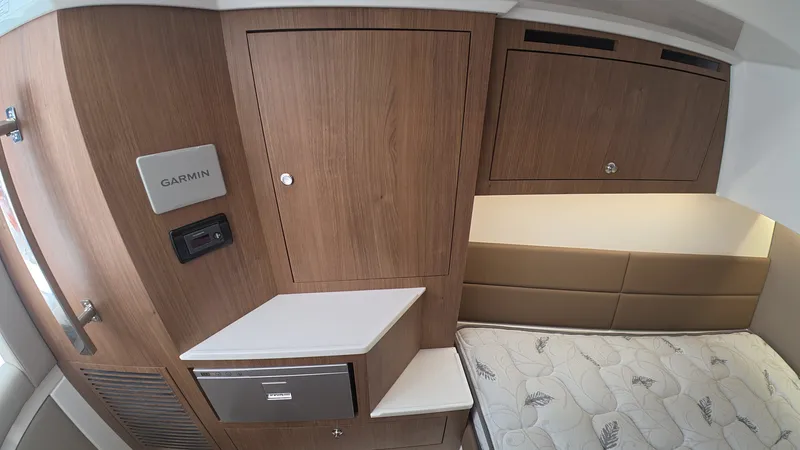 Slide: The Image of Interior of an Intrepid 35 PANACEA with wood paneling, a bed, and a Garmin device. - 28