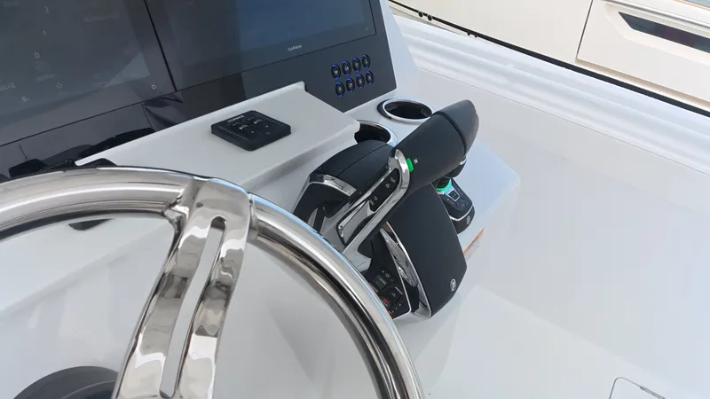 Slide: The Image of The image shows the steering wheel and controls of a 2027 Intrepid 35 PANACEA boat. - 24