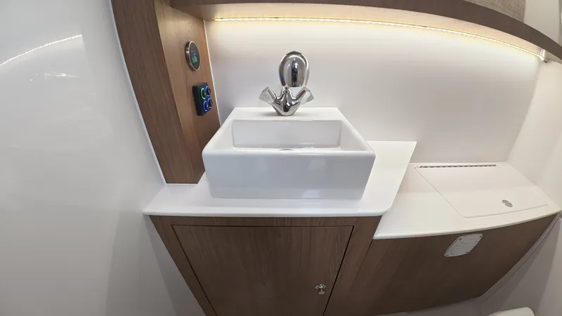 Slide: The Image of The image shows a modern boat bathroom with a stylish sink and wood paneling. - 37