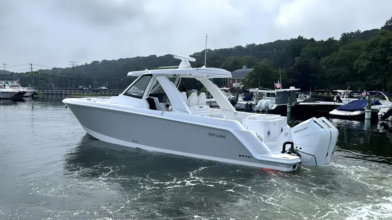 Slide: The Image of Intrepid 35 PANACEA 2027 on calm water, featuring twin outboard engines and a sleek design. - 2
