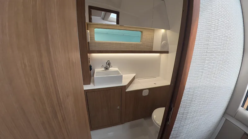 Slide: The Image of The image shows a modern boat bathroom with wood paneling and a sink. - 34
