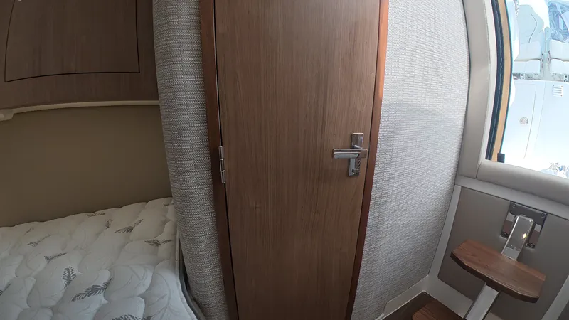 Slide: The Image of Interior of the 2027 Intrepid 35 PANACEA with a wooden door and bed. - 33