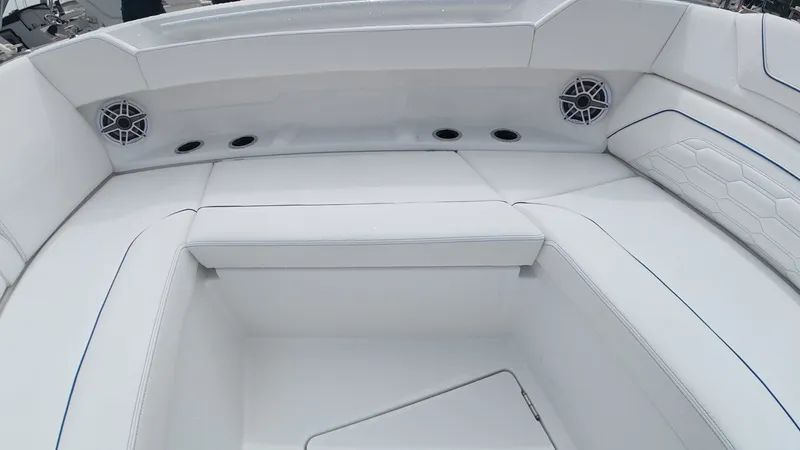 Slide: The Image of The image shows the white seating area of an Intrepid 35 PANACEA boat with speakers and cup holders. - 44
