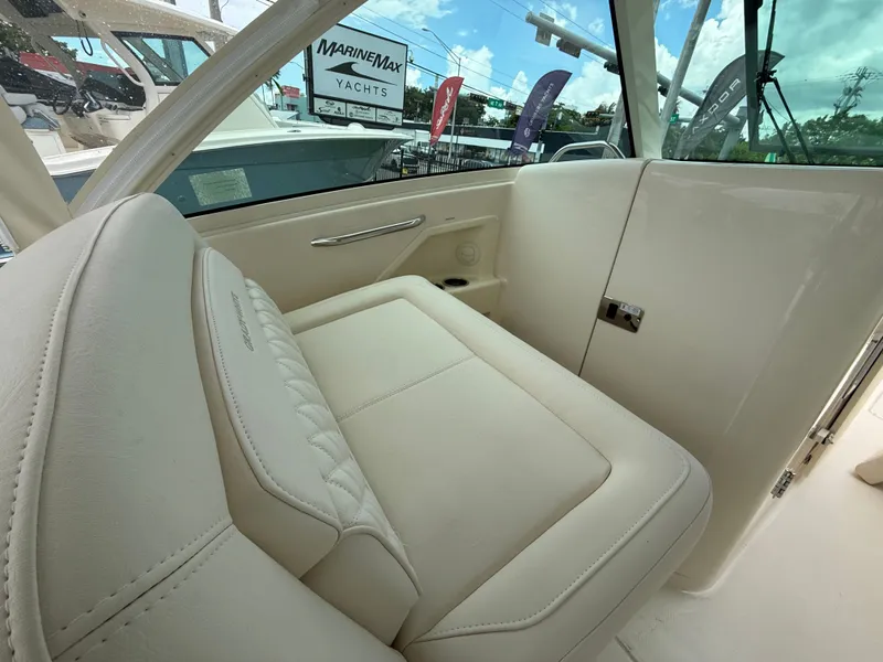 Slide: The Image of The 2027 Grady-White Freedom 325 features a luxurious cream-colored bench seat in the cockpit area. - 22
