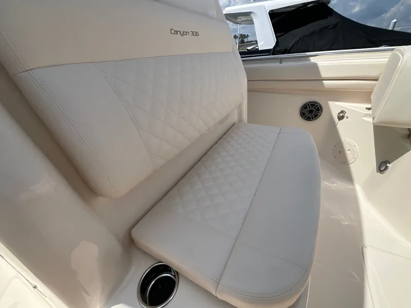 Slide: The Image of The 2027 Grady-White Canyon 306 features luxurious cream upholstery with a quilted pattern. - 21