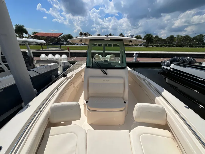 Slide: The Image of The image shows the cockpit of a 2027 Grady-White Canyon 306 with beige seating and a clear sky. - 16