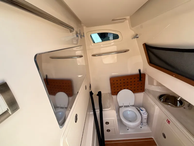 Slide: The Image of Interior of a Grady-White Canyon 306 with a toilet, sink, and storage space. - 18