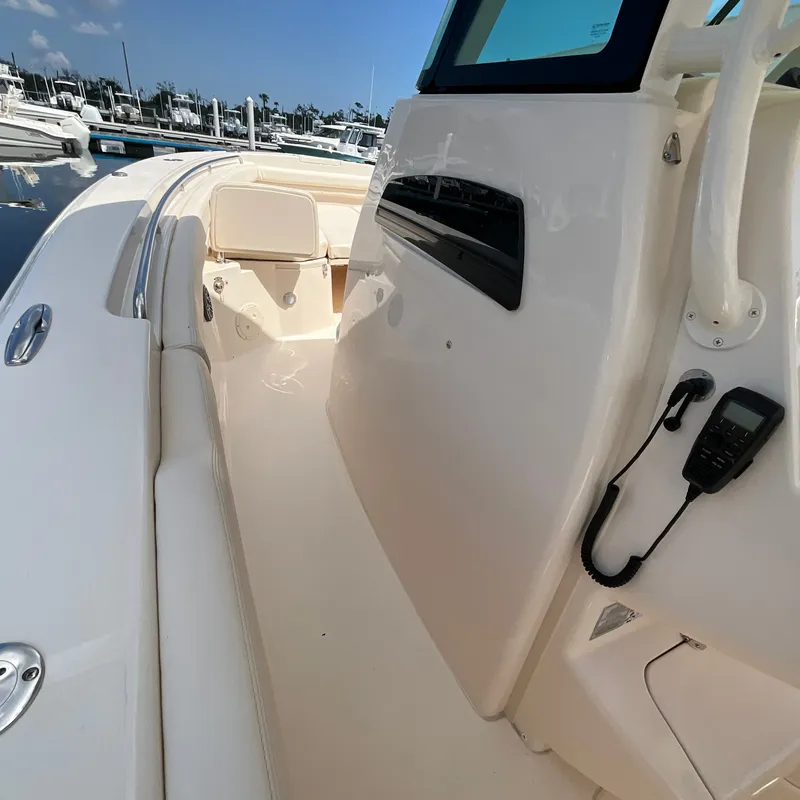 Slide: The Image of The image shows the deck of a 2027 Grady-White Canyon 306. It features a clean, white surface with a helm station and built-in speaker. - 24