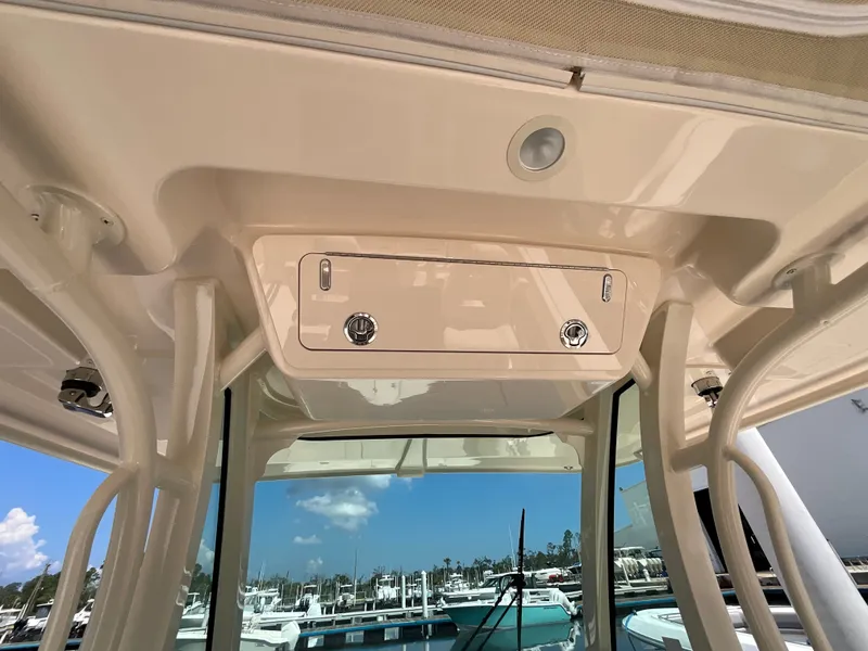 Slide: The Image of The image shows the cockpit roof of a Grady-White Canyon 306 boat at a marina. - 12